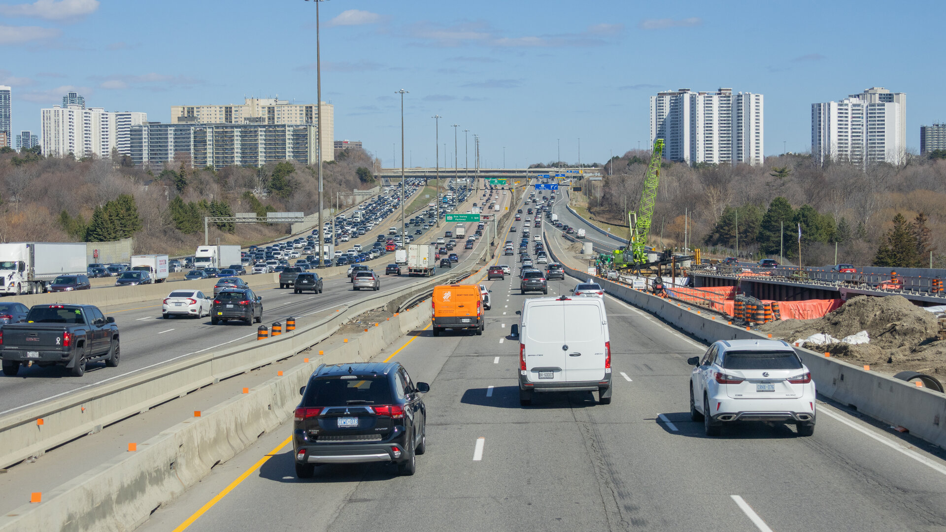 Highway 401 eastbound in North York, Toronto, with traffic and an active construction zone visible on the right shoulder.
